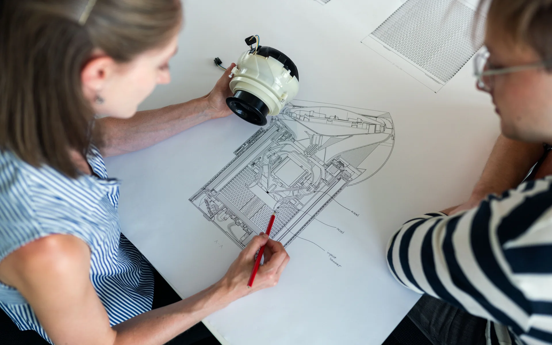 Engineers reviewing a detailed mechanical design and equipment component